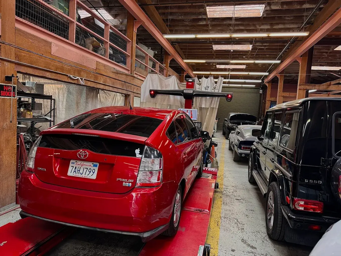 Vehicles in the service bay at Auto City Repair in San Francisco, with a car on the alignment rack